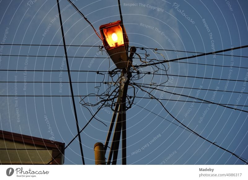 Power lines with street lighting on a line pole in the evening in Adapazari, Sakarya province, Turkey Street lighting Electricity pylon power line adapazari