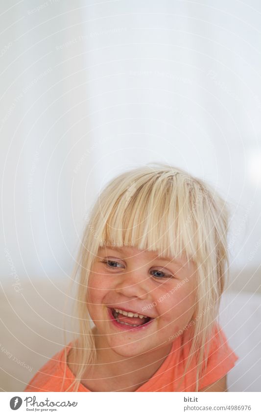 Natural blonde girl on bright neutral background, laughing into camera. Child, girl with bright eyes. Funny, witty portrait. Childhood, happiness, cheerfulness, humor. Beautiful childhood. Child, teeth, mouth. Cheeky, mischievous joker.