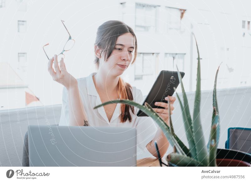 Young businesswoman checking her tablet holding glasses on terrace on the office during sunny day computer laptop one person working brunette business woman