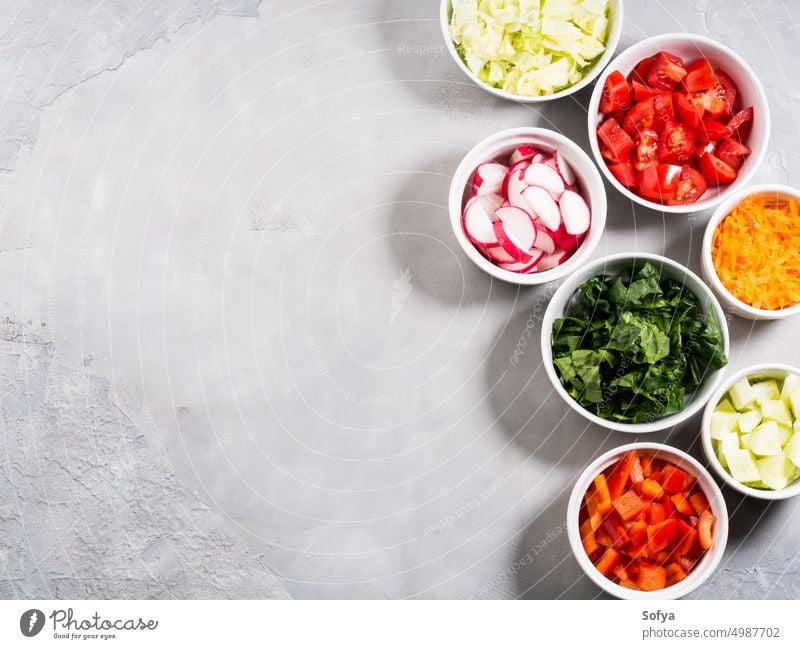 Mix of vegetable bowls for salad or snacks seasonal ingredient spring summer food diet tomato carrot spinach cucumber radish bell pepper green lettuce iceberg