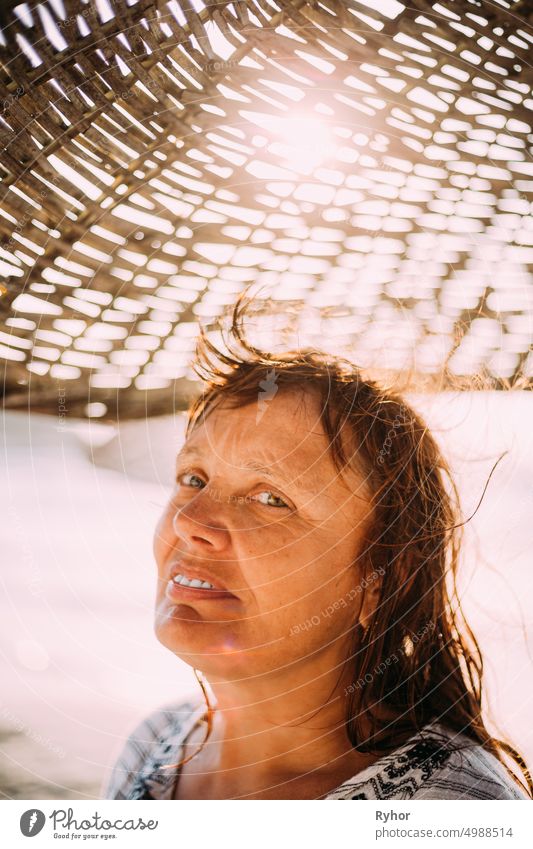 Adult Caucasian Woman Relaxed Posing Under Beach Umbrella On Sunset. Vacation On Sea Ocean adult attractive authentic beach beautiful beauty caucasian close