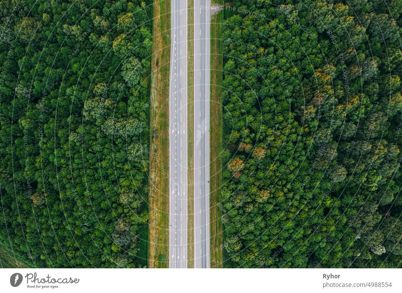 Aerial View Of Highway Road Through Green Forest Landscape In Summer. Top View Flat View Of Highway Motorway Freeway From High Attitude. Trip And Travel Concept