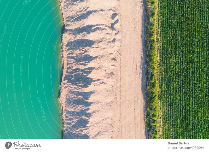 Landfill of the mined white fine aggregate between the turquoise lake and the farmland. Background. background beautiful blue design environment field flowing