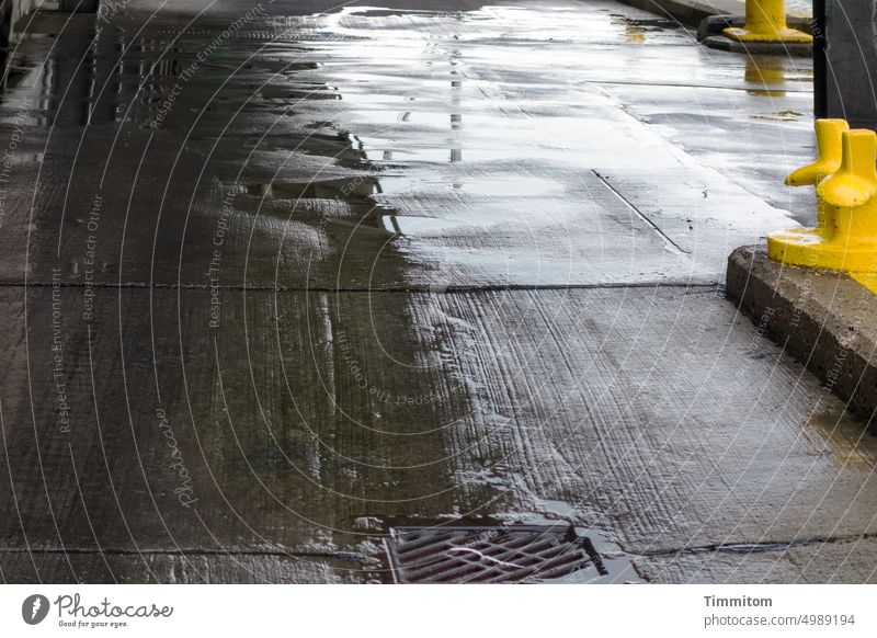 Wetness in the port area Harbour Ground Concrete Water wet expire Metal grid light and dark Reflection Bollard Yellow Denmark