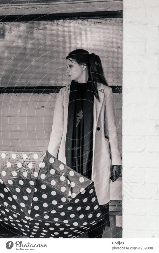 [HH Unnamed Road] Young woman with dotted umbrella stands in front of a wall and looks to the side Woman Umbrella Rain Human being Weather Umbrellas & Shades