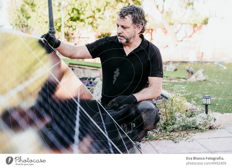 mature Technician man checking solar panels for self consumption energy. Renewable energies and green energy concept technician roof photovoltaic tools engineer