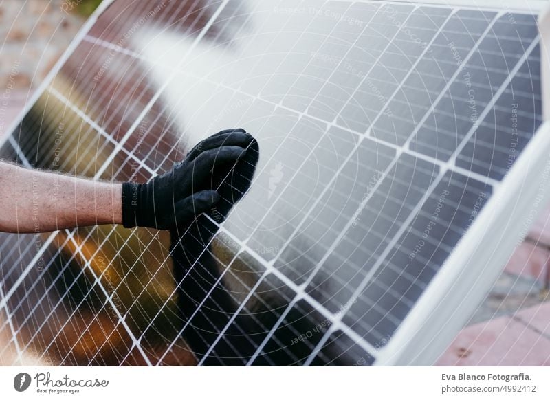 close up view of mature Technician man checking solar panels for self consumption energy. Renewable energies and green energy concept technician roof