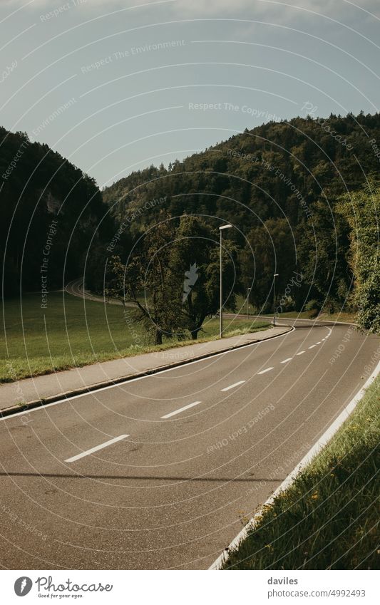 Beautiful mountain road in the Austrian Alps. alps asphalt countryside curve dashed direction drive empty europe forest green hill journey landscape line