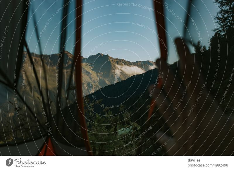 Beautiful mountains viewed from the interior of a camp tent at sunrise in the Alps activity adventure alps austria background backpack beautiful blue