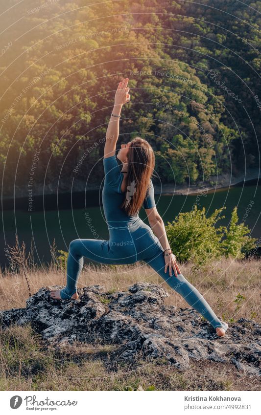 Yogi woman on top of high mountain doing yoga practice with deep breathing. Stretching body. Wild nature, free human. Freedom, Healthy lifestyle, everyday practice.