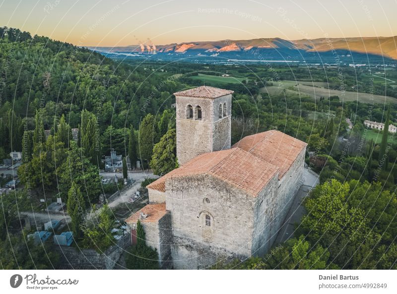 A bird's eye view of the Sainte-Foy church in one of the prettiest towns in France - Mirmande. In the background, a view of the Cruas nuclear power plant aerial