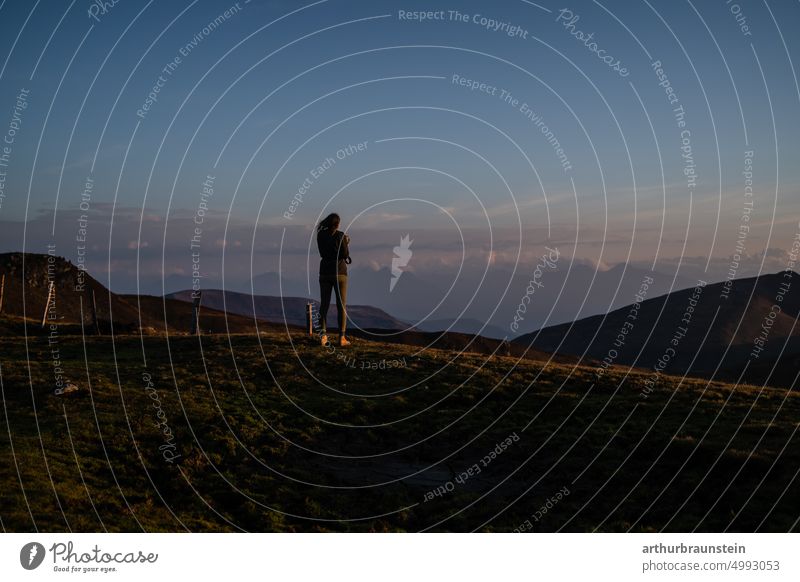 Young woman with camera at sunrise on mountain under blue sky mountains mountain panorama Movement out Photography Take a photo Freedom free time early