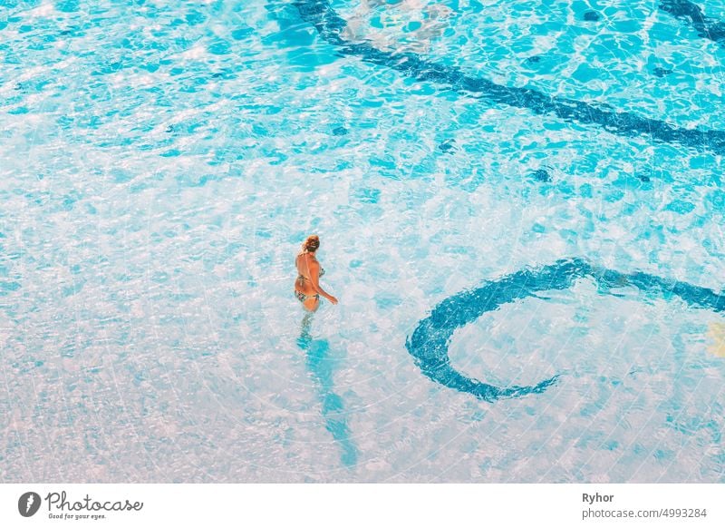 Adult Caucasian Lady Woman Standing In Hotel Swimming Pool In Sunny Summer Day. Vacation In Hotel active active lifestyle adult alone authentic beautiful