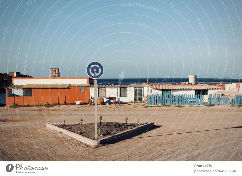 An empty traffic circle in front of the sea Traffic circle Directions Road marking Street Transport Traffic infrastructure Orientation Lanes & trails