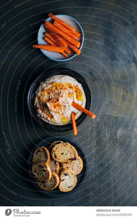 Homemade hummus ready to serve appetizer bowl bread carrot chickpea creamy dip food healthy homemade Hummus lunch oil olive oil paprika parsley snack tahini