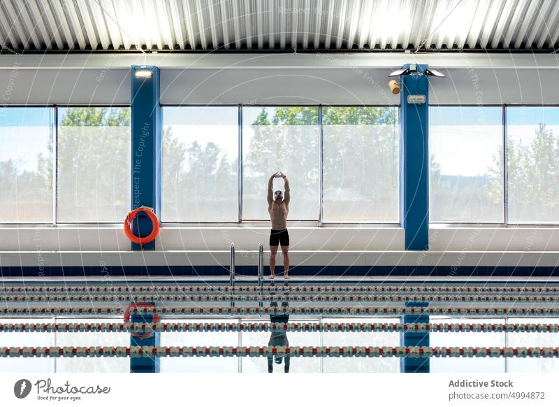 Swimmer with goggles reflecting in pool indoors athlete swimming sport strong naked torso masculine body man prepare swimmer lifesaver reflection shirtless