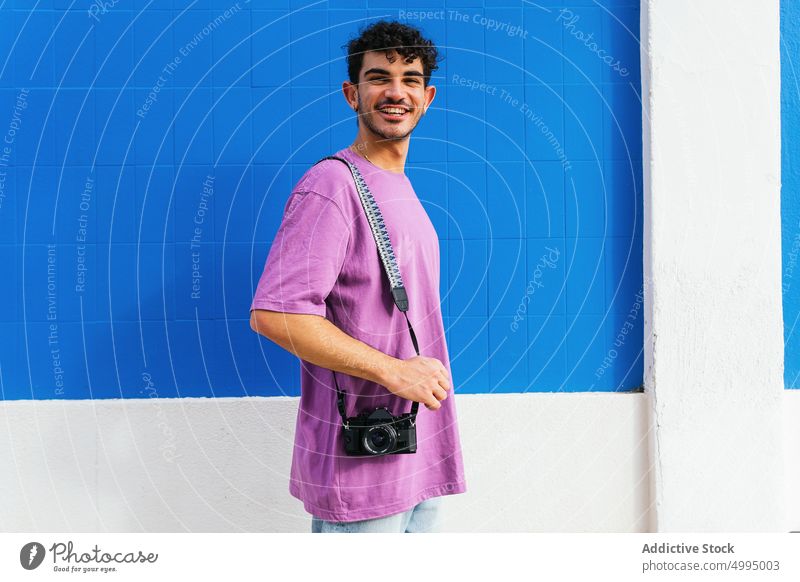 Happy man taking photo outside modern building take photo photographer street photo camera shoot urban hobby male young hispanic smile happy ethnic memory glad