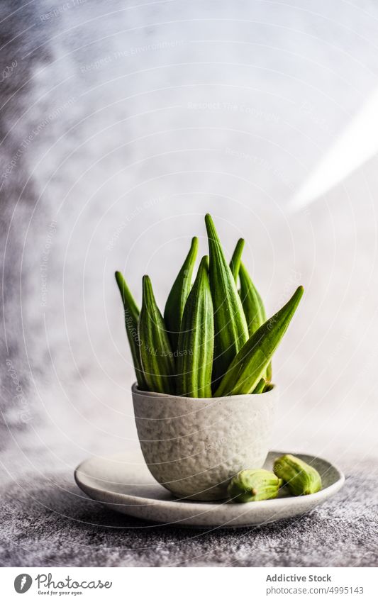 Raw okra in bowls background bamia bamya cook cooking cuisine food green healthy himalayan salt mix pepper cloth oil organic raw flat lay table vegan