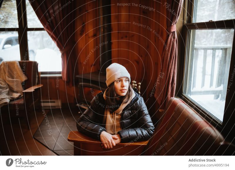 Female traveler inside wooden cabin woman hut beanie weekend winter trip bench window hat visit season valley of the ghosts monts valin quebec canada