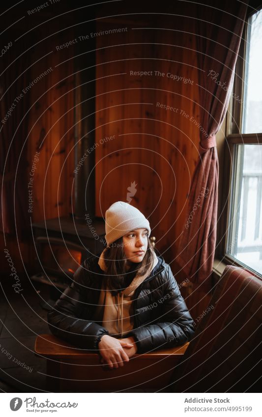 Female traveler inside wooden cabin woman hut beanie weekend winter trip bench window hat visit season valley of the ghosts monts valin quebec canada