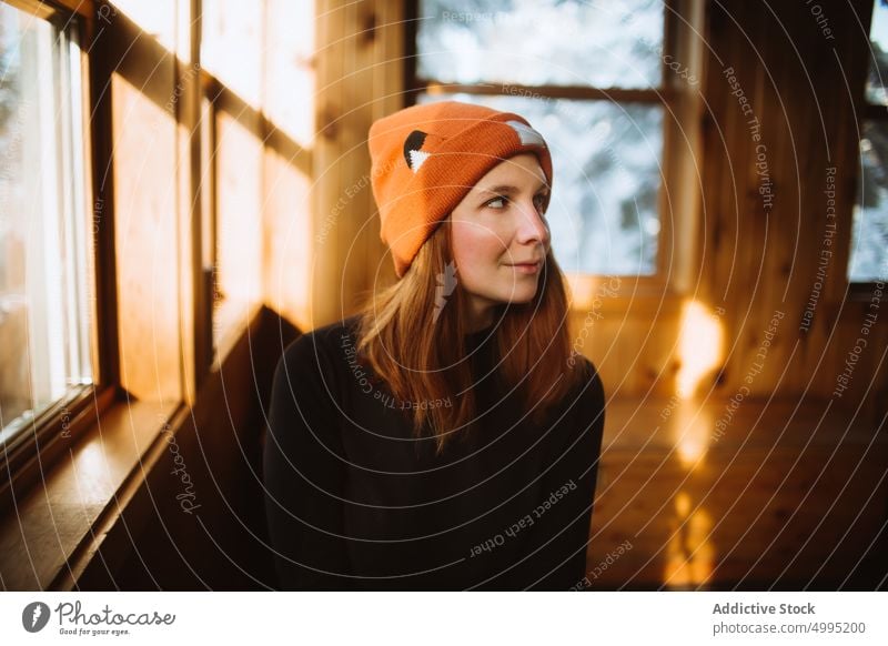 Female traveler inside wooden cabin woman hut beanie weekend winter trip bench window hat visit season valley of the ghosts monts valin quebec canada