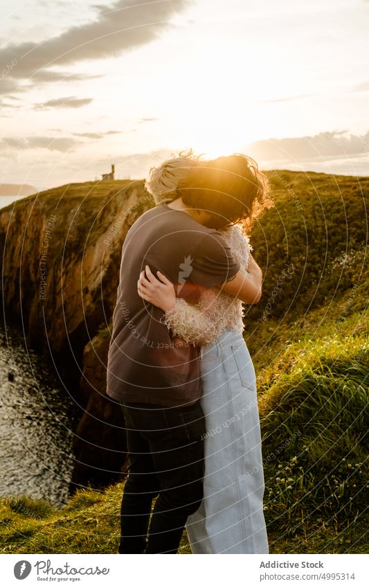 Anonymous couple hugging on cliff at sunset sea sky cloudy love relationship date aviles asturias spain nature sundown countryside girlfriend boyfriend romantic