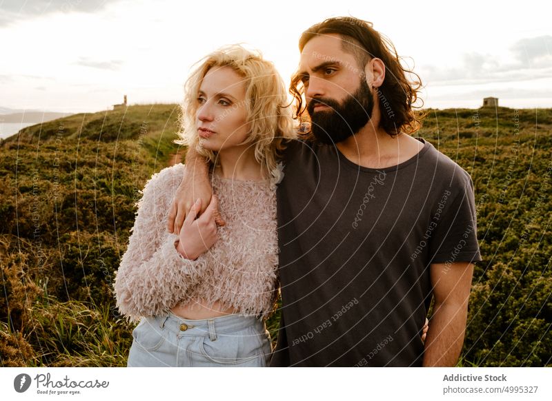 Couple hugging and looking away at sunset couple cliff admire together date love relationship romantic aviles asturias spain evening sundown countryside dusk