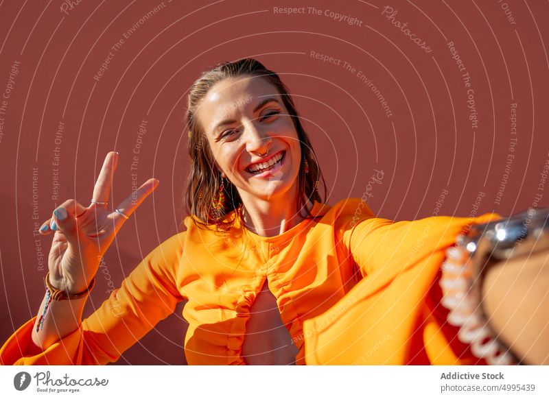 Happy female taking selfie on street woman happy funny modern urban v sign two fingers grimace style young carefree cheerful memory tourist traveler neon summer