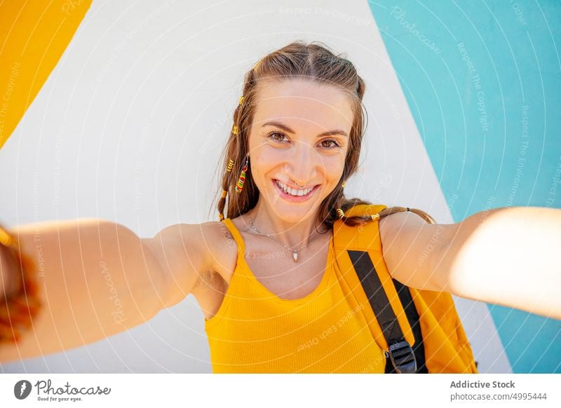 Happy female taking selfie on street woman happy funny modern urban style young carefree cheerful backpack memory tourist traveler neon summer moment lifestyle