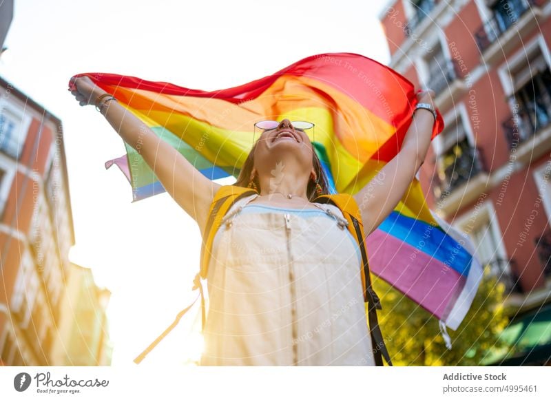 Happy young woman with transgender flag lgbt smile street pride support happy summer female positive optimist sunglasses crop top homosexual carefree glad