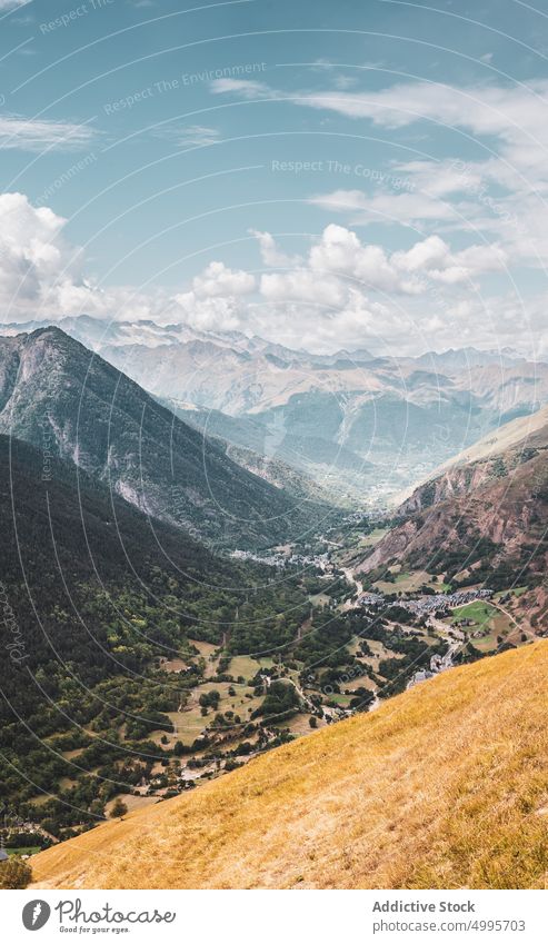 Scenic mountainous valley under cloudy blue sky in Catalonia landscape nature highland range village picturesque scenery slope ridge scenic rocky settlement