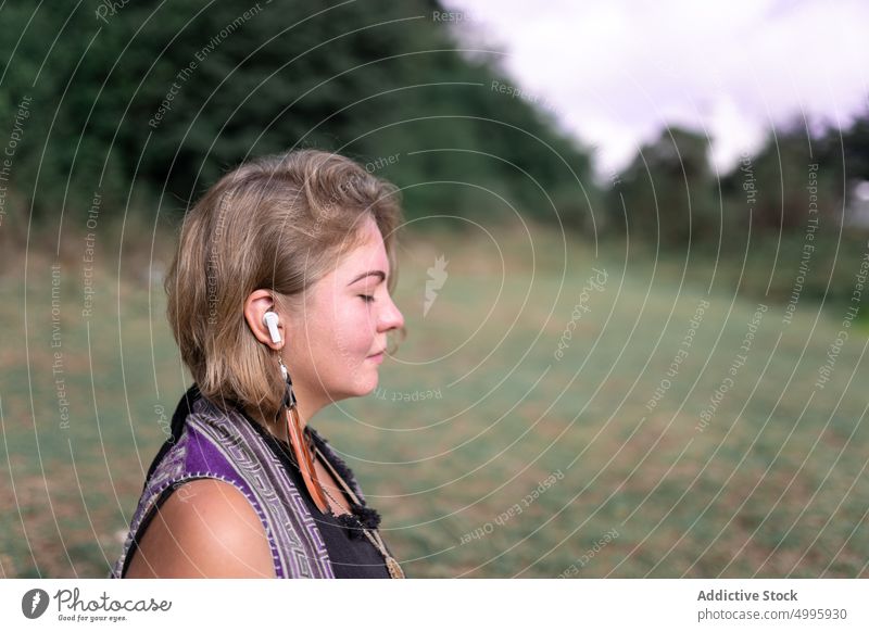 Tranquil young lady meditating with closed eyed on meadow woman meditate eyes closed listen music calm recreation spirit stress relief harmony countryside