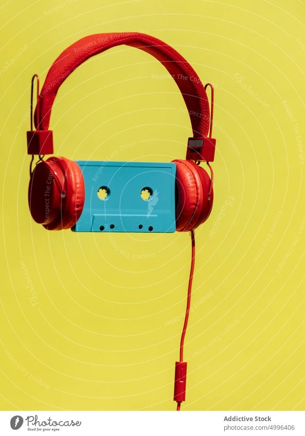 Retro cassette in headphones on yellow background audio listen music retro tape vintage colorful nostalgia album bright classic stereo old sound record headset