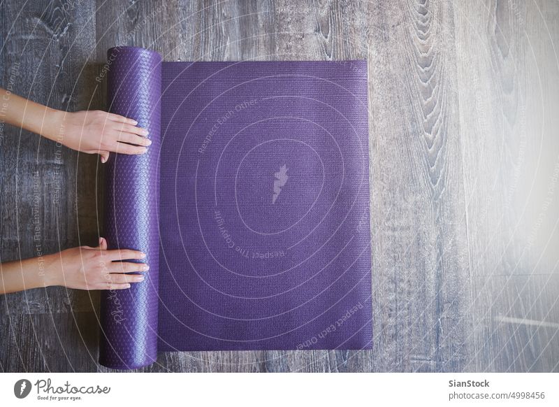 Woman rolling her mat after a yoga class studio young woman exercise fitness pose beautiful workout body person health meditation healthy female background