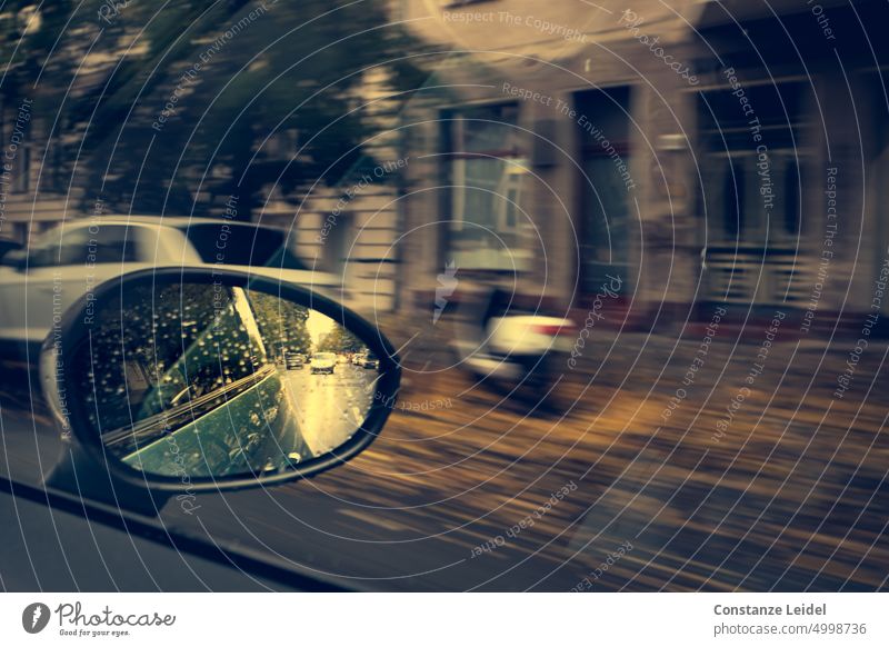 Street scene in exterior mirror and view of house facade and scooter in ICM technique cloudy weather Building Downtown rainy ICM technology car traffic Tourism