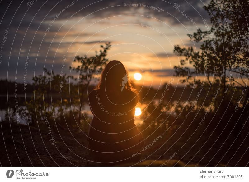 Girl looks at the sunset on the lake Swede Lake Sunset from behind Woman Orange Clouds Sky reflection centered tranquillity relaxation focus