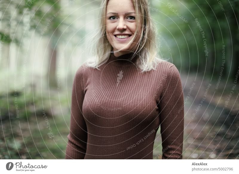 Young blonde woman standing in forest smiling happily to camera Young woman Woman Blonde Feminine pretty fortunate Youth (Young adults) portrait Adults