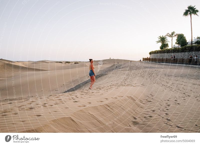 Tourist on the Maspalomas desert dune woman walking maspalomas sand Gran Canaria copy space Canary islands Spain tourist travel hiking outdoors hike sunset