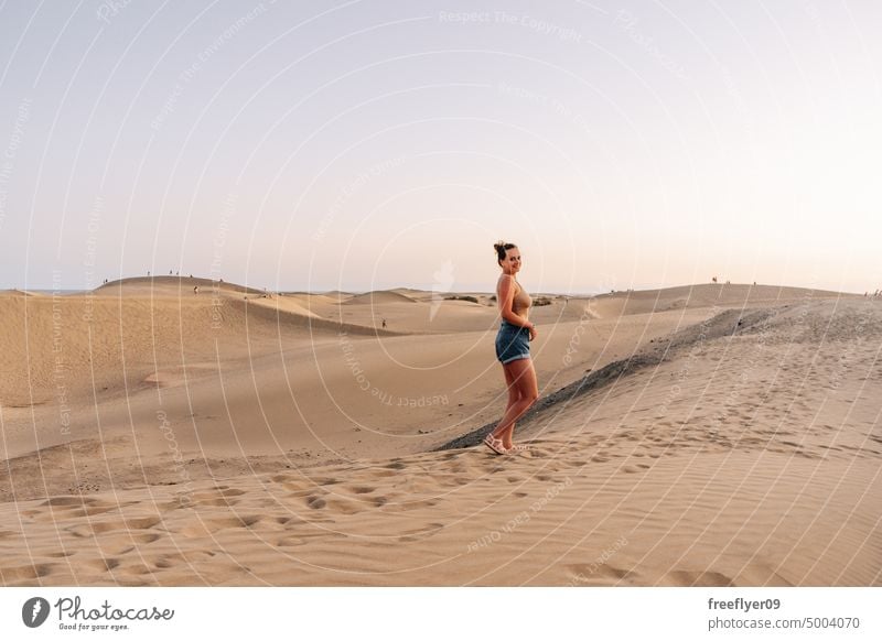 Tourist on the Maspalomas desert dune woman walking maspalomas sand Gran Canaria copy space Canary islands Spain tourist travel hiking outdoors hike sunset