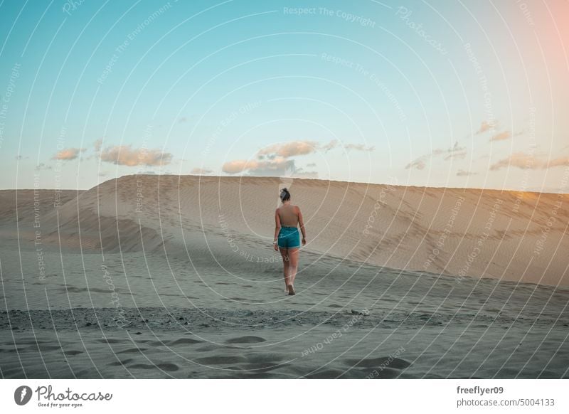 Tourist on the Maspalomas desert dune woman walking maspalomas sand Gran Canaria copy space Canary islands Spain tourist travel hiking outdoors hike sunset