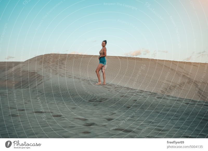 Tourist on the Maspalomas desert dune woman walking maspalomas sand Gran Canaria copy space Canary islands Spain tourist travel hiking outdoors hike sunset