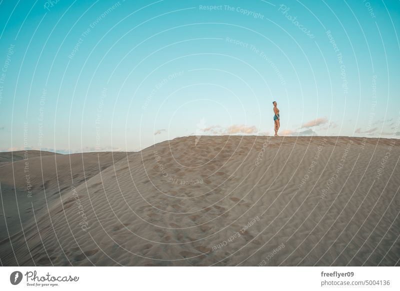 Portrait of a tourist on the Maspalomas desert dune woman walking maspalomas sand Gran Canaria copy space Canary islands Spain travel hiking outdoors hike