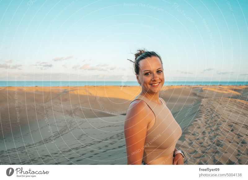 Portrait of a tourist on the Maspalomas desert dune woman walking maspalomas sand Gran Canaria copy space Canary islands Spain travel hiking outdoors hike