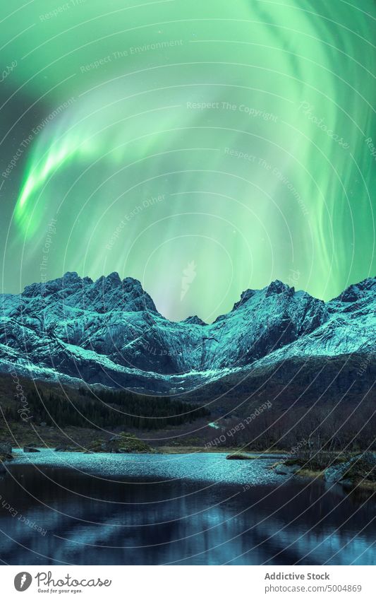 Aurora borealis in night sky over snowy mountains aurora borealis northern polar light lake winter illuminate norway lofoten islands nature breathtaking coast