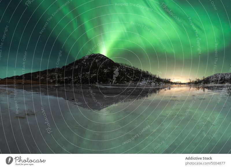 Aurora borealis in night sky over snowy mountains aurora borealis northern polar light lake winter illuminate norway lofoten islands nature breathtaking coast