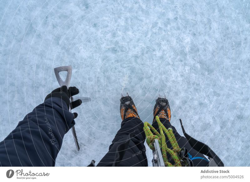 Crop mountaineer on icy ground ice axe glacier explore travel cold winter frozen nature iceland vatnajokull national park wanderlust climate countryside