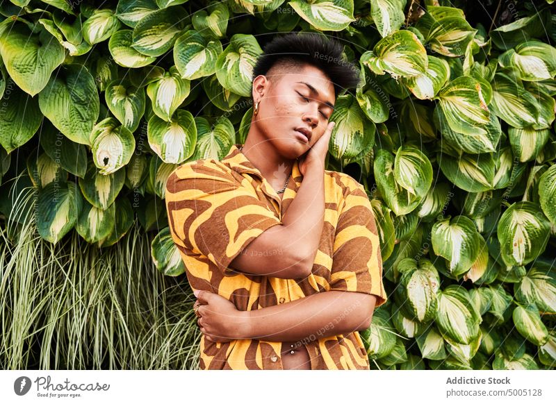 Sensual non binary guy embracing himself in garden man self love accept imperfection lgbt alternative embrace tolerance identity lgbtq city park sunglasses