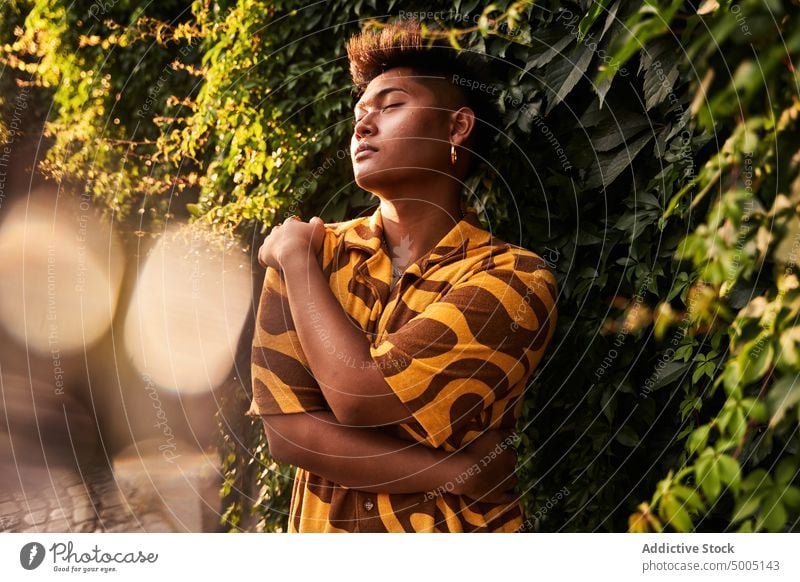 Sensual non binary guy embracing himself in garden man self love accept imperfection lgbt alternative embrace tolerance identity lgbtq city park sunglasses