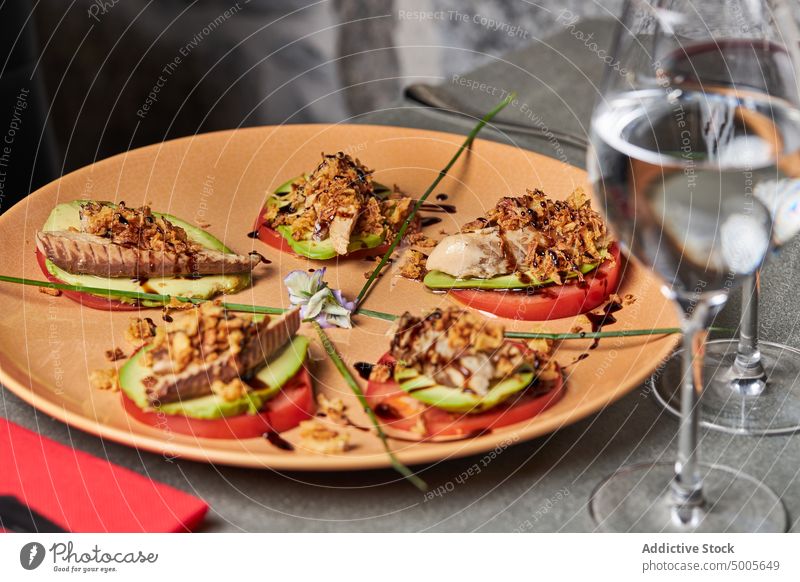 Vegetable and fish salad on plate vegetable dish avocado tomato mackerel onion restaurant flower green edible stack portion food tasty vegetarian gourmet serve