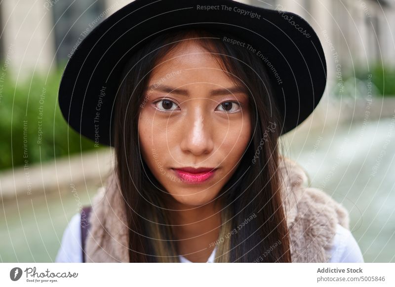 Charming Hispanic woman in hat appearance style trendy fashion feminine headwear street charm long hair lady headdress hispanic latin red lips female attractive